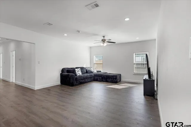 a living room with furniture and wooden floor