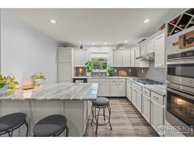a kitchen with granite countertop kitchen island white cabinets and appliances