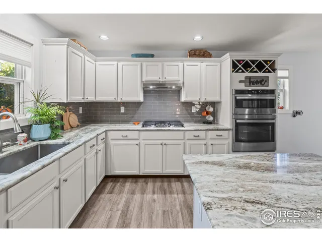 a kitchen with kitchen island white cabinets appliances and a sink