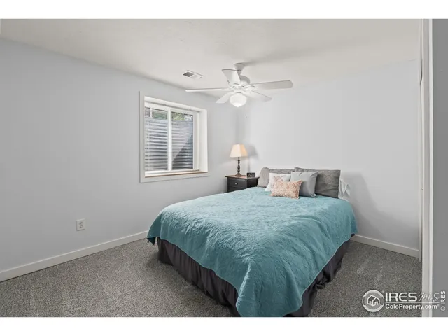 a bedroom with a bed chandelier and a window