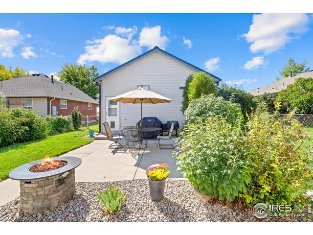 a patio with a table and chairs under an umbrella