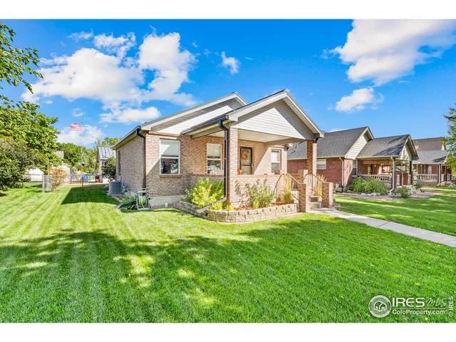 a view of a house with a big yard potted plants and large tree