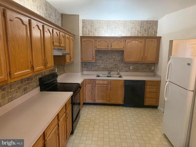 a kitchen with a stove a sink and a refrigerator