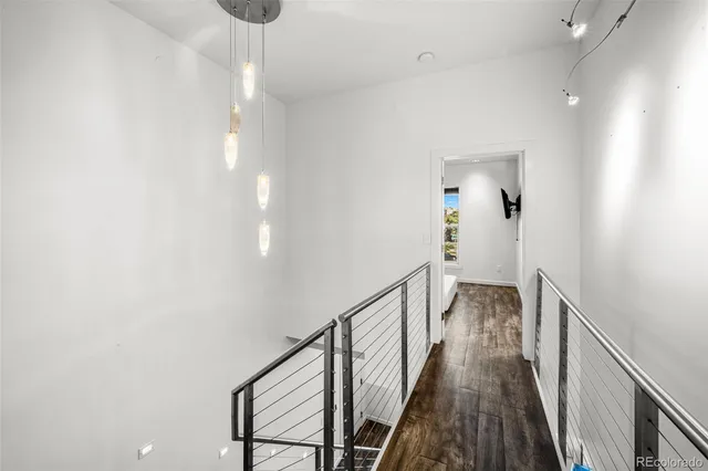 a view of a hallway with wooden floor and staircase
