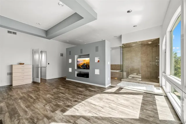 a view of a livingroom with wooden floor and a flat screen tv