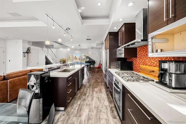 a kitchen with stainless steel appliances granite countertop a stove a sink dishwasher and cabinets with wooden floor