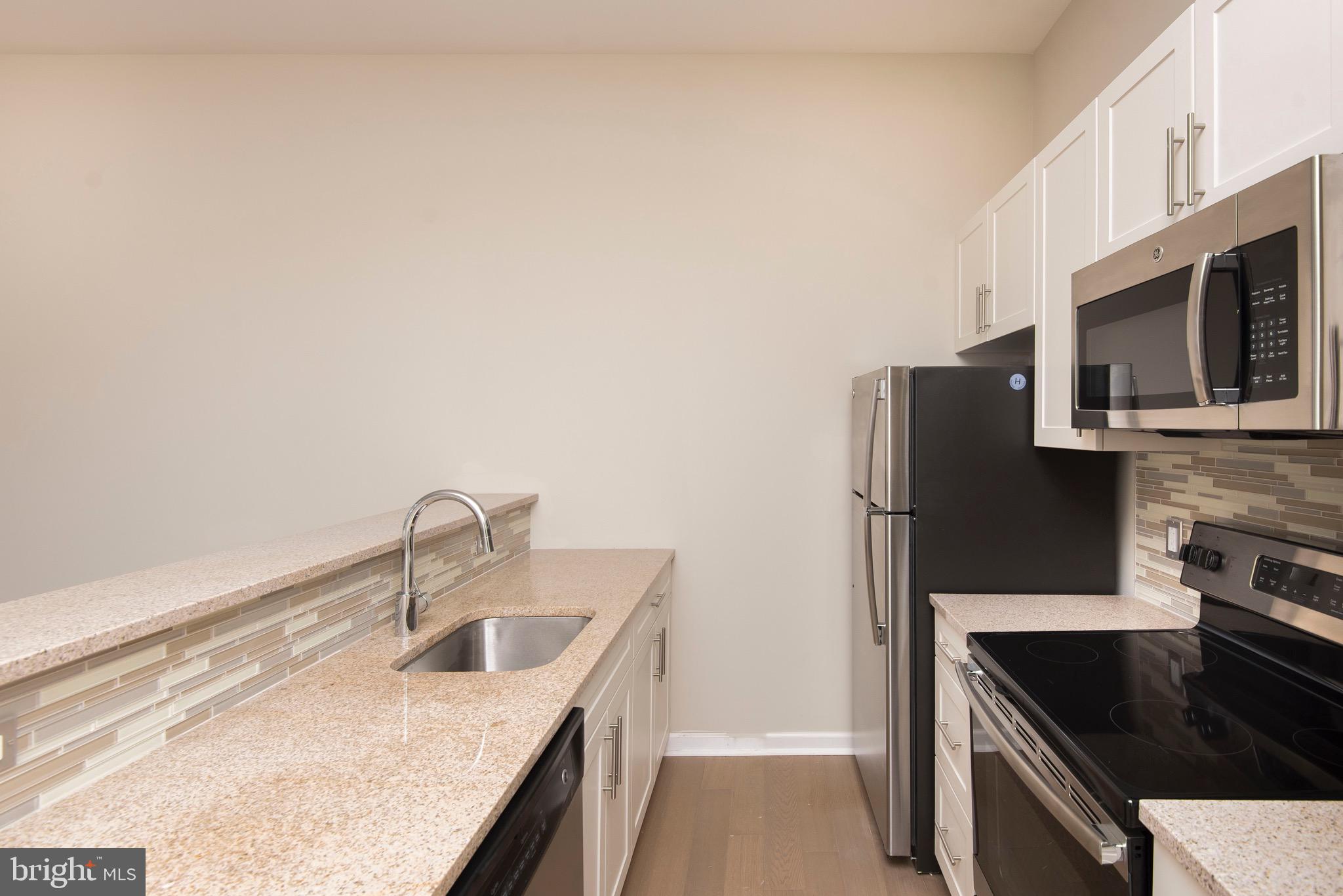 103 South Gay Street, Unit 1BR Baltimore, MD 21202 - Photo 42 of 92 a kitchen with stainless steel appliances granite countertop a sink stove and refrigerator