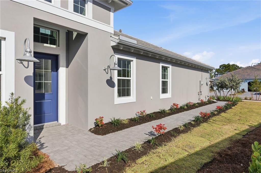 8937 Calypso Court Naples, FL 34113 - Photo 4 of 43 a front view of a house with a yard
