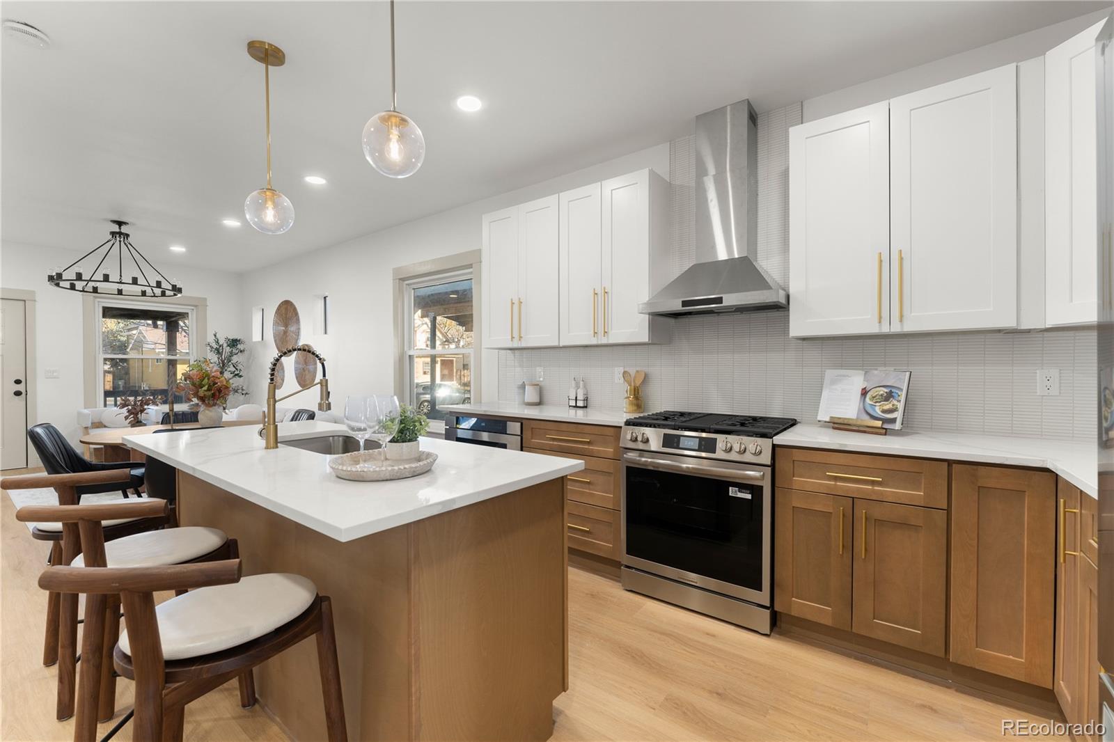 2963 South Lincoln Street Englewood, CO 80113 - Photo 11 of 50 a kitchen with a stove a sink a dining table and chairs
