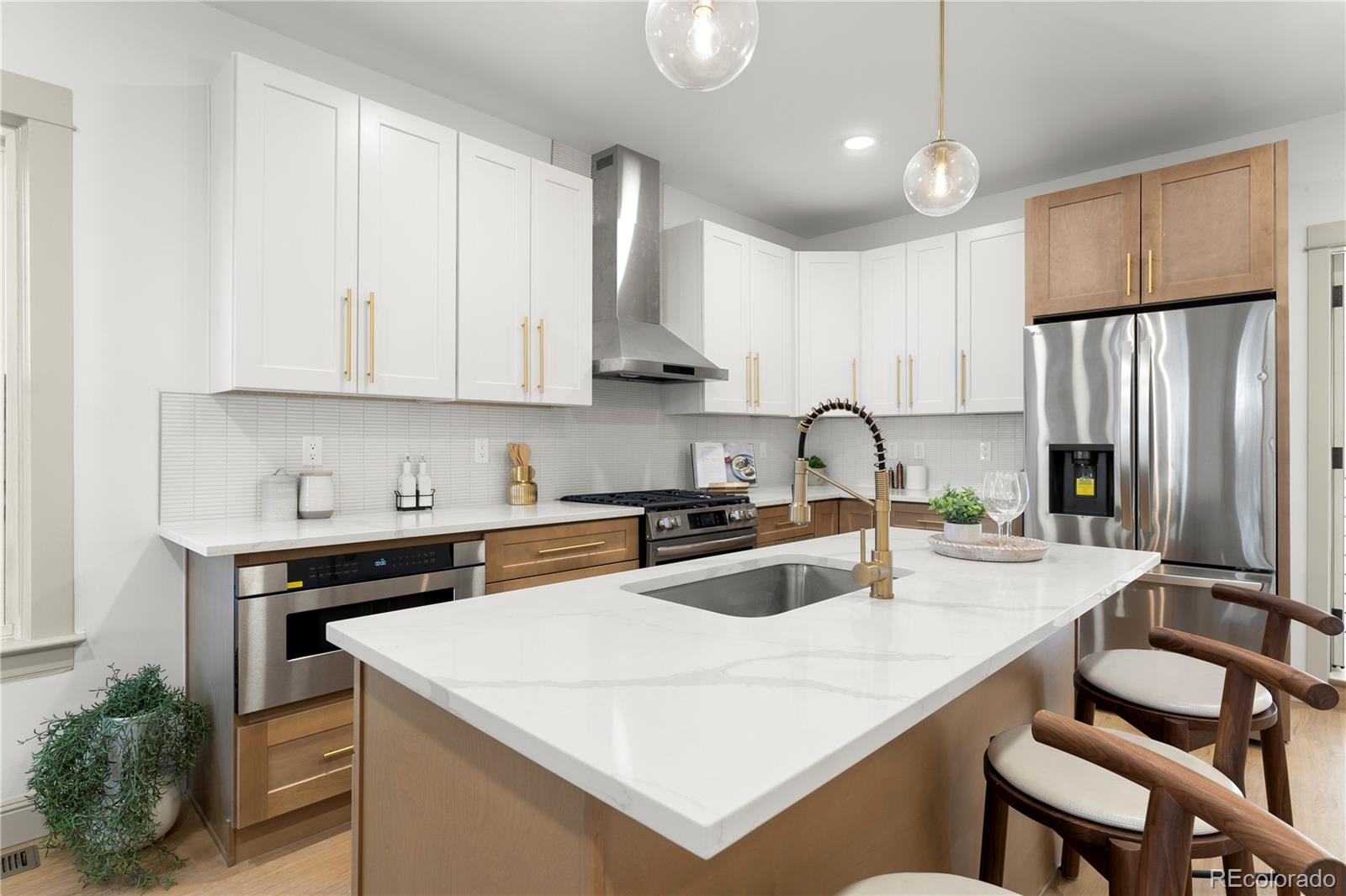 2963 South Lincoln Street Englewood, CO 80113 - Photo 10 of 50 a kitchen with a sink a stove a refrigerator and white cabinets with wooden floor