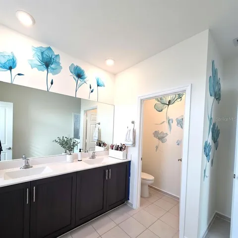 a bathroom with a double vanity sink mirror and toilet