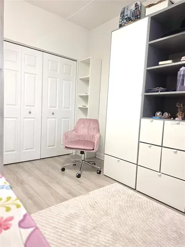 a bedroom with a bed a rug a wall painting and a shower