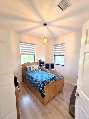 a bedroom with a bed window and wooden floor