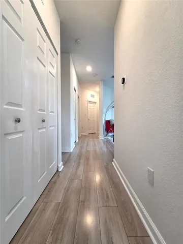 a view of hallway with wooden floor