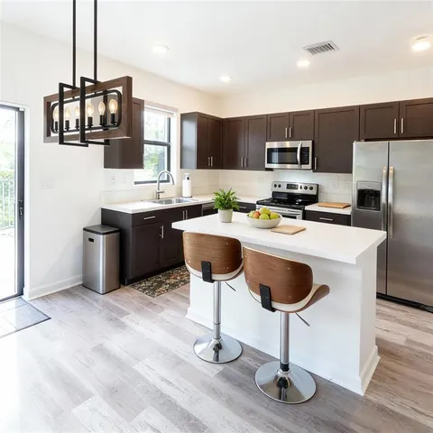 a kitchen with stainless steel appliances a stove refrigerator and microwave