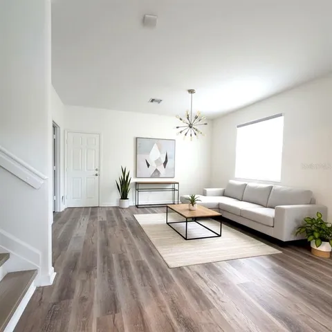 a living room with furniture and a chandelier