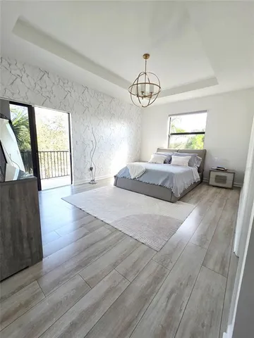 a spacious bedroom with a bed and a chandelier