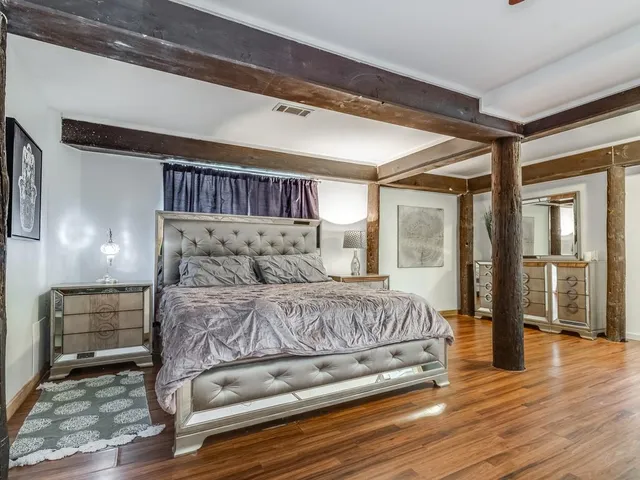 a bedroom with a bed and wooden floor
