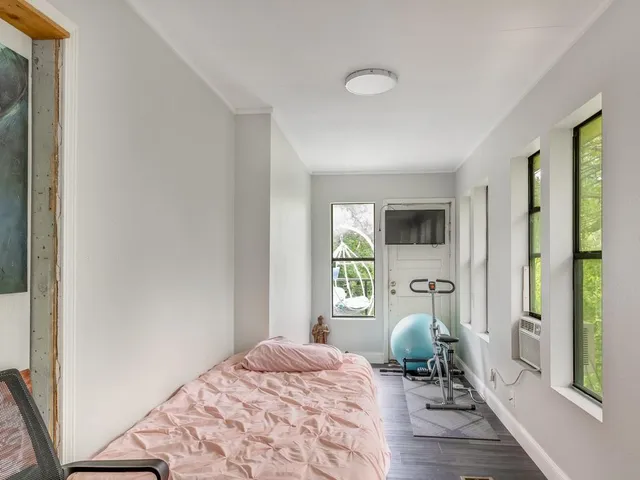 a bedroom with a bed and wooden floor