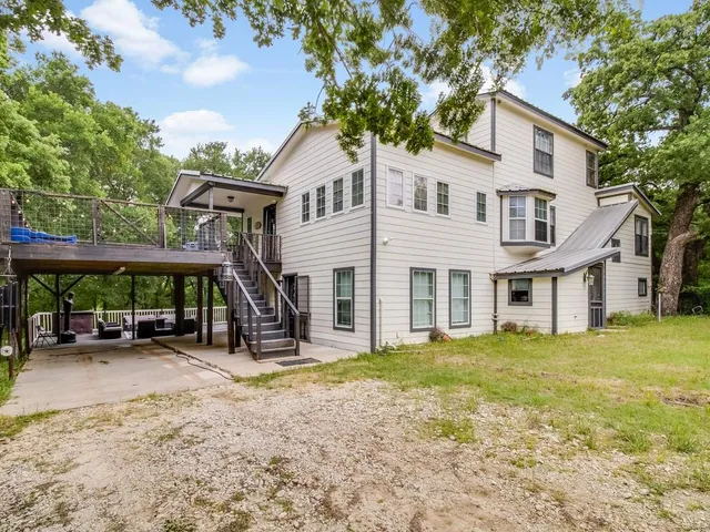a view of a house with backyard and a tree