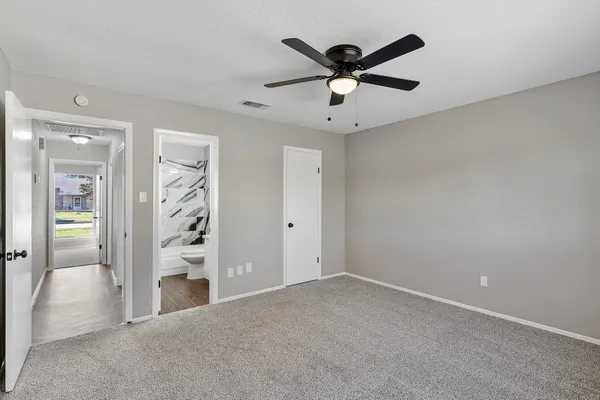 an empty room with closet and a ceiling fan