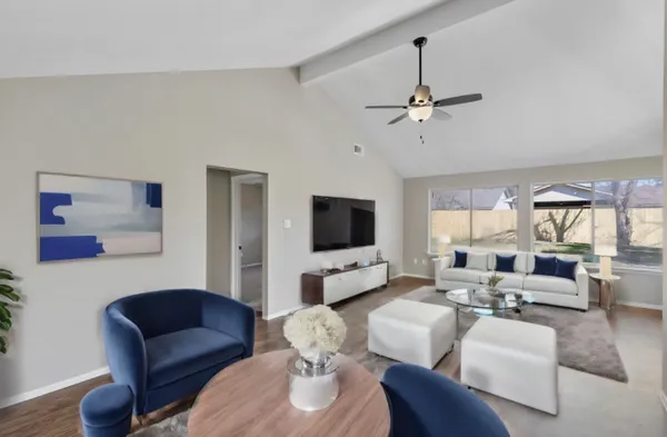 a living room with furniture ceiling fan and a window