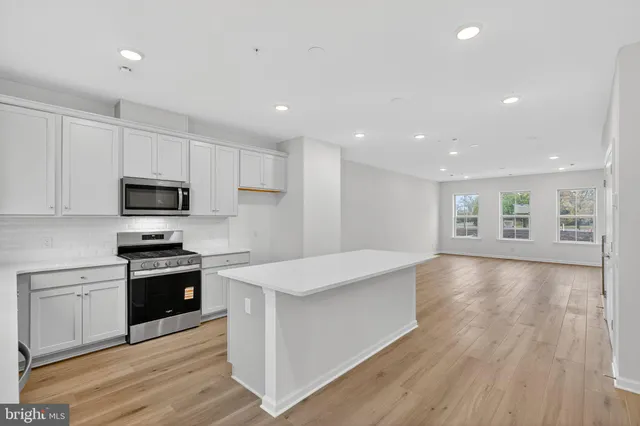 a large kitchen with stainless steel appliances granite countertop a stove a sink and a refrigerator