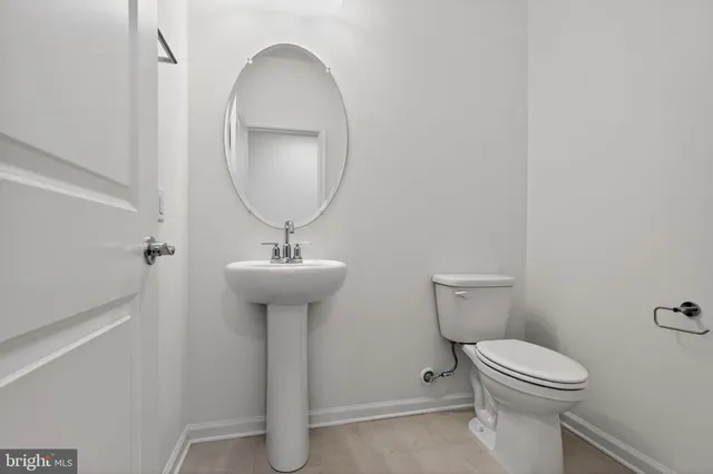 a bathroom with a toilet a sink and a mirror