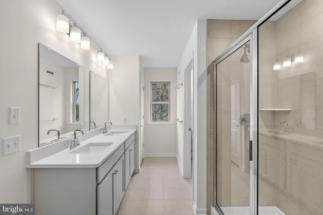 a bathroom with a double vanity sink mirror and shower