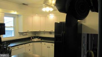 1408 Mt Airy Road Rosedale, MD 21237 - Photo 4 of 22 a kitchen with a sink a refrigerator and cabinets