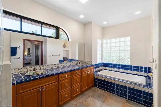 a bath room with a sink and a large mirror