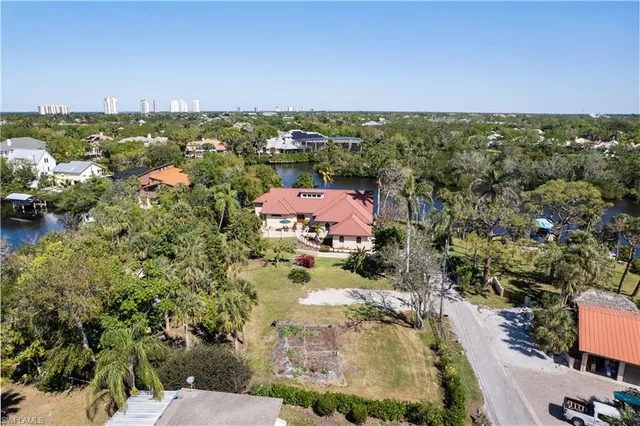 an aerial view of residential houses with outdoor space and trees