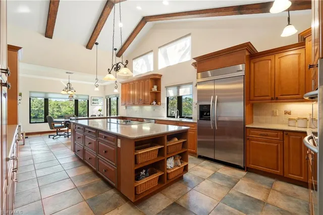 a kitchen with stainless steel appliances granite countertop a stove a sink and a refrigerator
