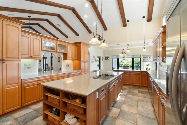 a dining hall with stainless steel appliances granite countertop a sink and a refrigerator