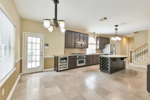 a large kitchen with a lot of counter space and a chandelier