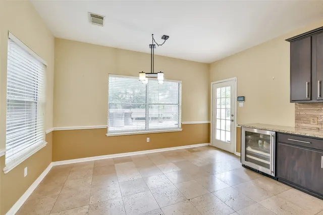 a view of an empty room with window cabinet and a kitchen