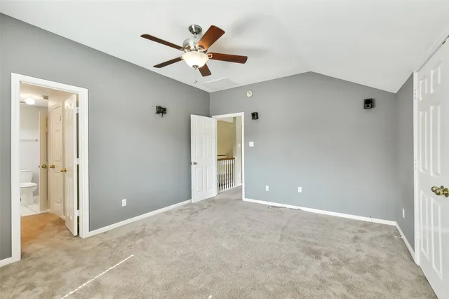 an empty room with closet and a chandelier fan