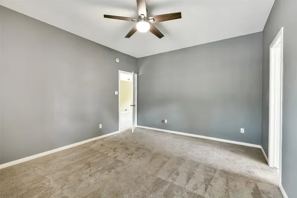 a view of an empty room and a ceiling fan