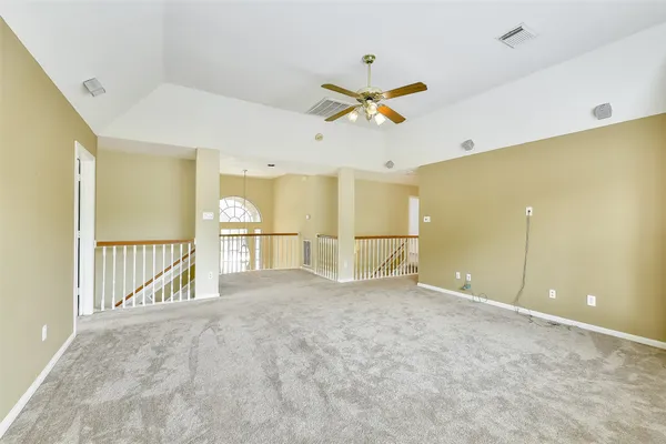 a view of a livingroom with a ceiling fan and kitchen view