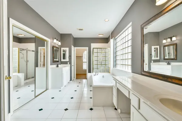 a large white kitchen with a large window and stainless steel appliances