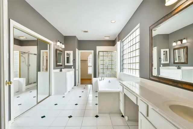 a large white kitchen with a large window and stainless steel appliances