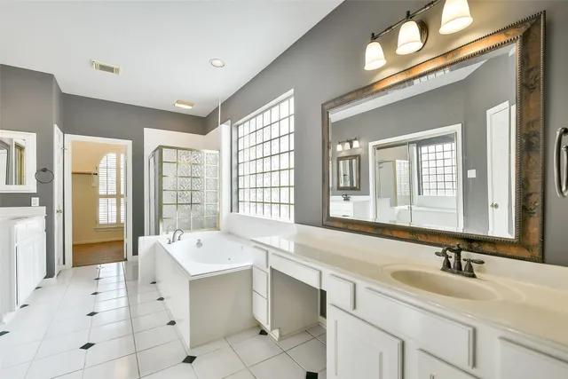 a bathroom with a sink double vanity mirror and a bathtub