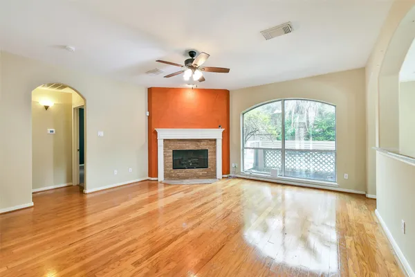 a view of an empty room with a window and wooden floor