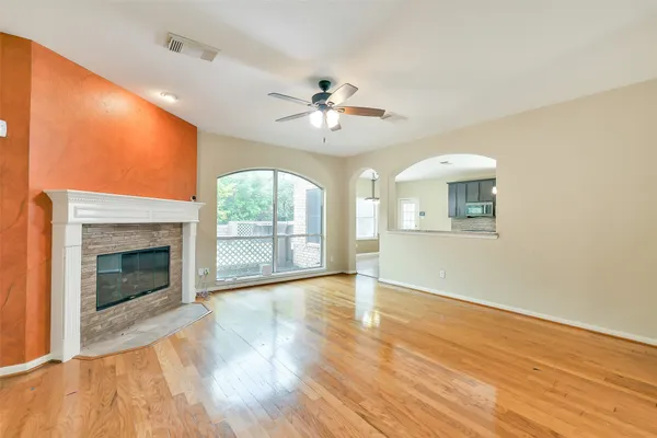 a view of an empty room with a fireplace and a window