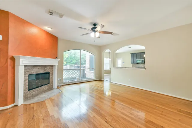 a view of an empty room with a fireplace and a window