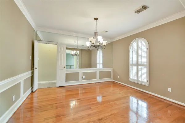 a view of an empty room with window and wooden floor