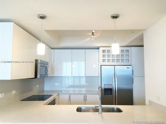 a kitchen with stainless steel appliances granite countertop a sink and a refrigerator