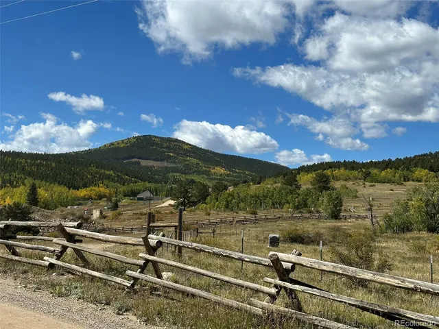 a city street lined with parked cars front of buildings