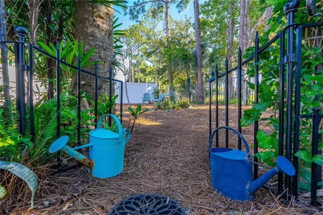 a view of a backyard with plants and chairs