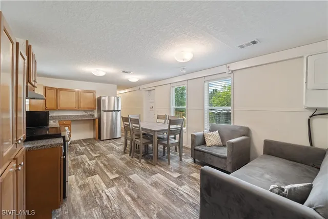a living room with furniture a large window and a dining table